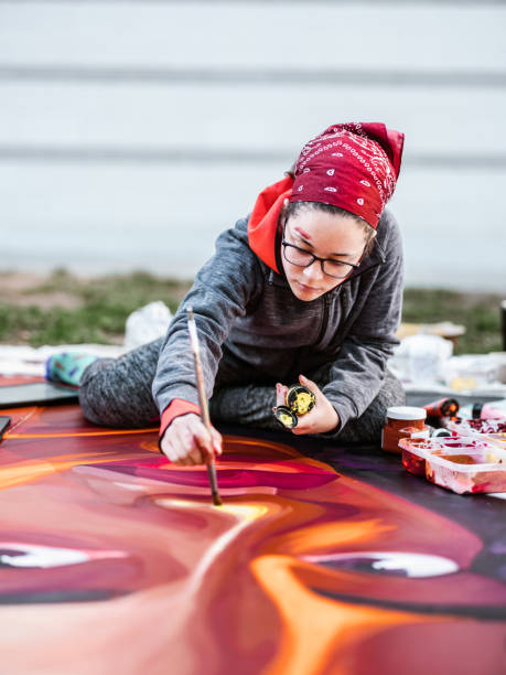 istock Young Latin woman creating outdoor mural 1428150735