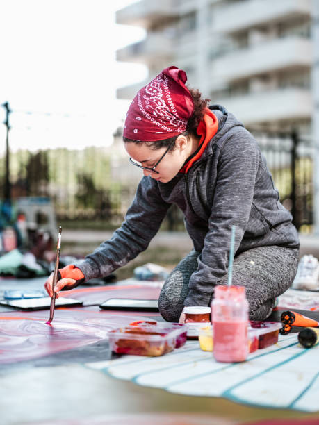 istock Young Latin woman creating outdoor mural 1428150739