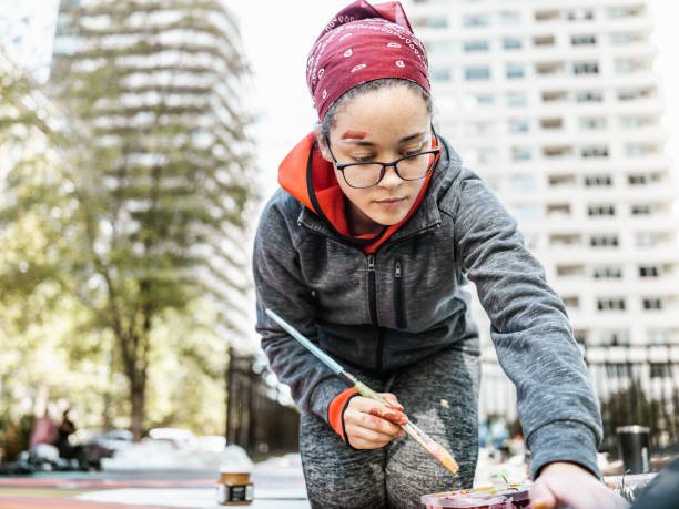 istock Young Latin woman creating outdoor mural 1428154205