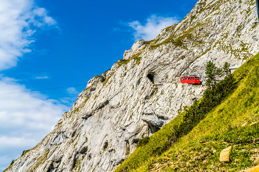 Colorful Cogwheel Rail Car Climbing Mount Pilatus Lucerne Switzerland. Steepest cogwheel railway in World, climbing to Mt. Pilatus observation point