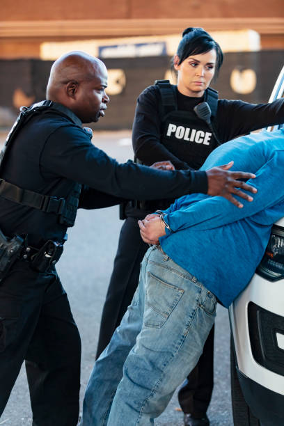 istock Two police officers arresting a suspect, handcuffed 1428169322