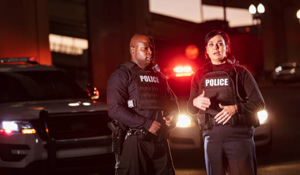 istock Two police officers talking at night, lights flashing 1428171044