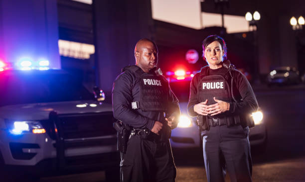 istock Two police officers talking at night, lights flashing 1428171057