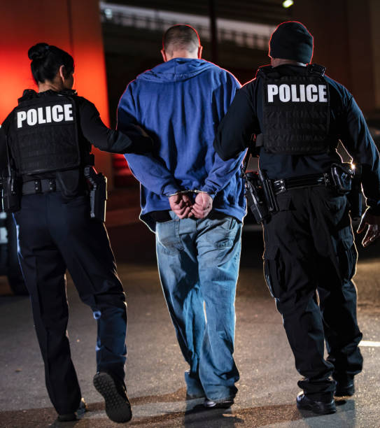 istock Handcuffed suspect being arrested by police at night 1428172127