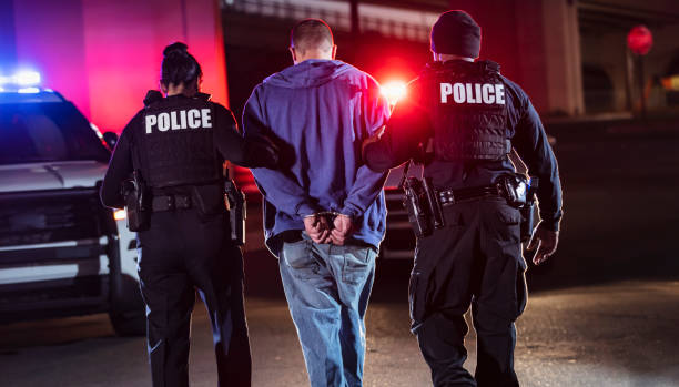 istock Handcuffed suspect being arrested by police at night 1428172137