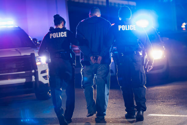 istock Handcuffed suspect being arrested by police at night 1428172139