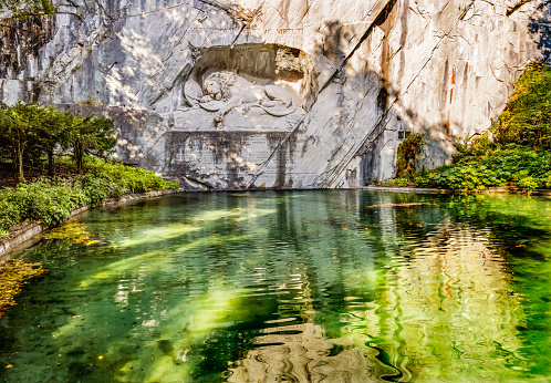 Dying Lion Rock Relief Reflection Cliff Lucerne Switzerland Created in 1821 by Bertel Thorvaldsen. Monument Swiss guards killed in 1792 protecting king French Revolution