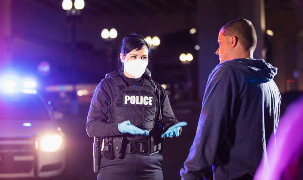 istock Policewoman in mask working at night questioning man 1428173255