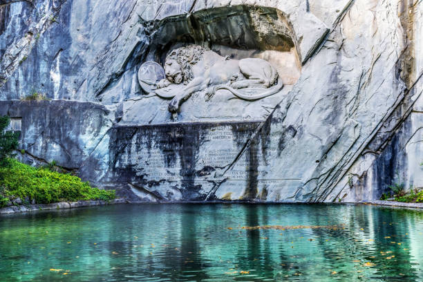 Dying Lion Rock Relief Reflection Cliff Lucerne Switzerland Created in 1821 by Bertel Thorvaldsen. Monument Swiss guards killed in 1792 protecting king French Revolution