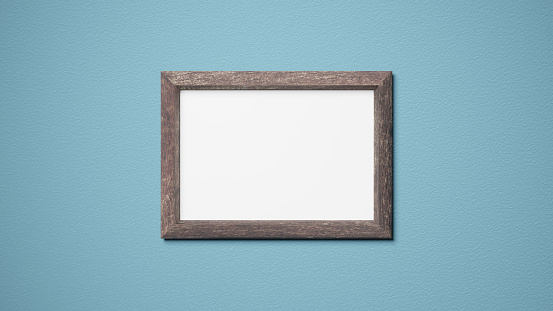 Brown wooden picture frame. Rectangular. Light blue walls with a rough texture.