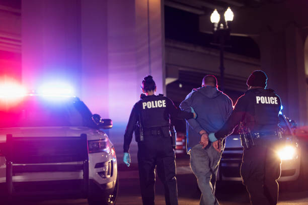 istock Police with handcuffed suspect at night 1428177167
