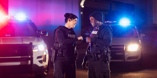 istock Two police officers working at night, bumping fists 1428178257