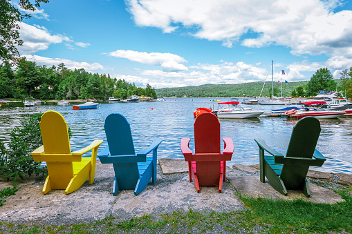Adirondack chairs sit overlooking a lake