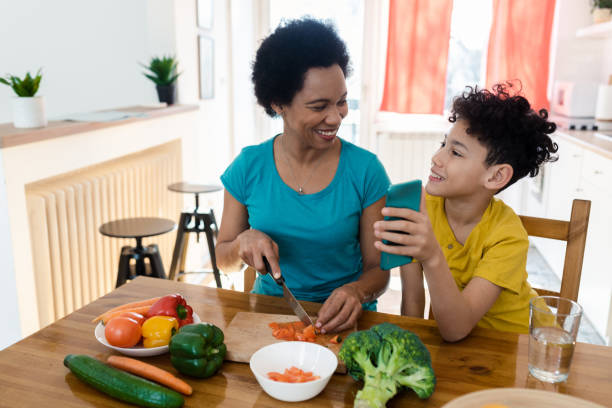 istock Boy showing a recipe to his mom while making a vegetable meal 1428190706