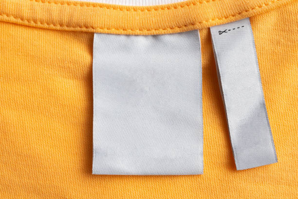 istock Blank white laundry care clothes label on yellow fabric texture background 1428193027