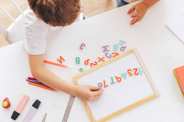 istock Schoolchildren study letters and lay them out hardly sitting at the table 1428193091