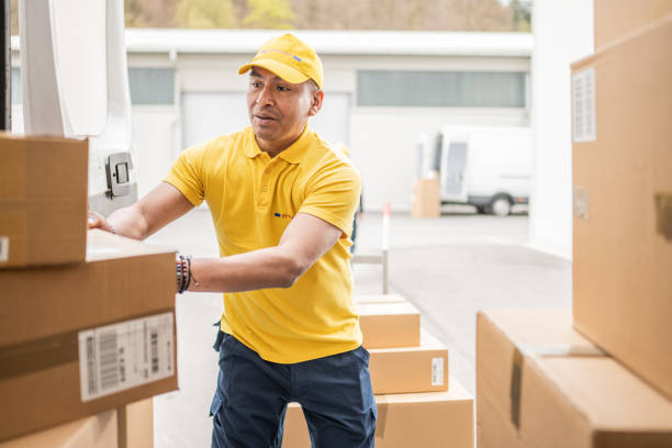 istock Delivery man unloading shipping service truck with cardboard boxes, view inside of van 1428193242