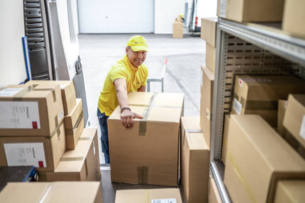 istock Delivery man unloading truck with boxes, high angle view inside of van 1428193243