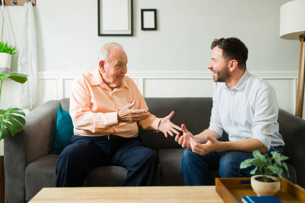 istock Cheerful elderly senior man and young man talking looking happy at home 1428204242