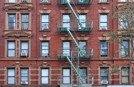 Old fashioned New York apartment building \nwith ornate window frames and exterior fire escape