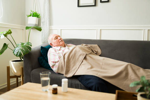 istock Sick elderly man taking medicine pills and sleeping on the sofa 1428204495