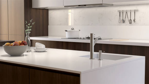 moderne und luxuriöse kücheninsel und theke aus holz mit weißer quarz-arbeitsplatte und spüle im sonnenlicht aus dem fenster auf grauer marmorwand - domestic kitchen kitchen sink contemporary counter top stock-fotos und bilder