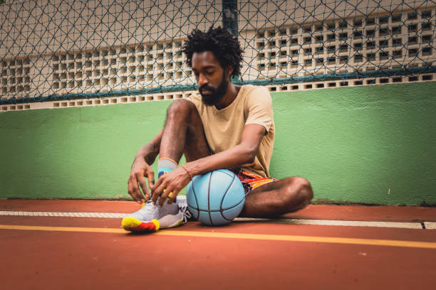 istock Basketball player tying sneakers on court 1428212785