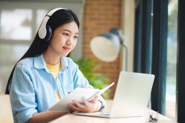 istock Young asian learning online using laptop stting at table. 1428218866