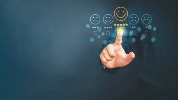 Photo of Man touching the virtual screen on the happy smiley face icon to give satisfaction in service. Rating very impressed. Customer service and satisfaction concept.