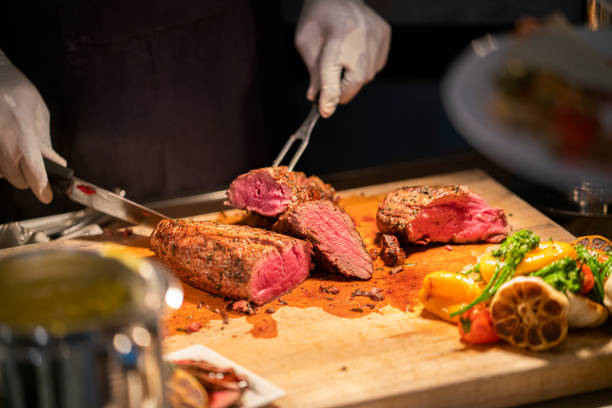 istock Cook cutting and serving Filet MIgnon at a catering event 1428228272