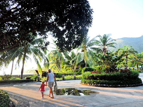 Grandmother with grandchild  walking along coastline. Enjoying  beach vacation. Soft blurred focus