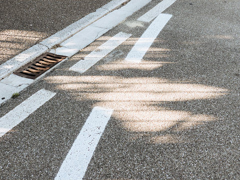 Sunlight casts  interesting shadows on an equally interesting set of road markings.
