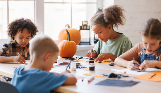 istock Happy multinational group of children making Halloween home decorations together 1428234197