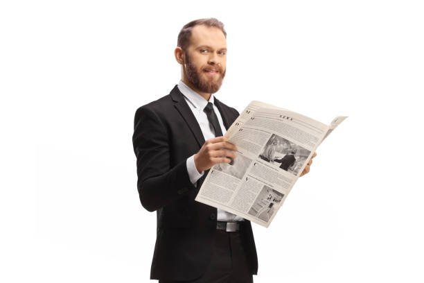 istock Professional man in a suit standing with a newspaper and smiling at camera 1428242634