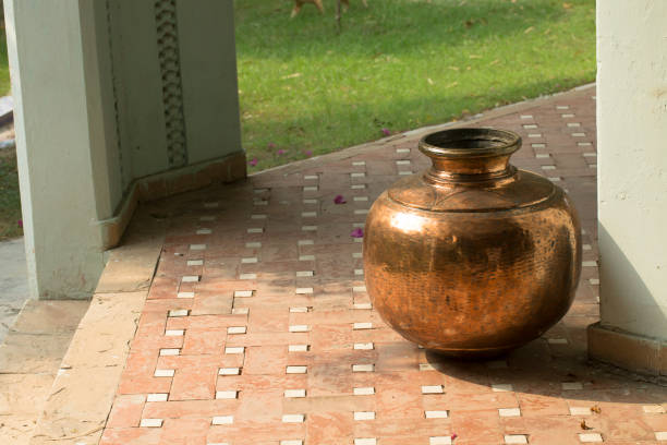 Brass pot on vintage terra cotta tile floor with negative space stock photo