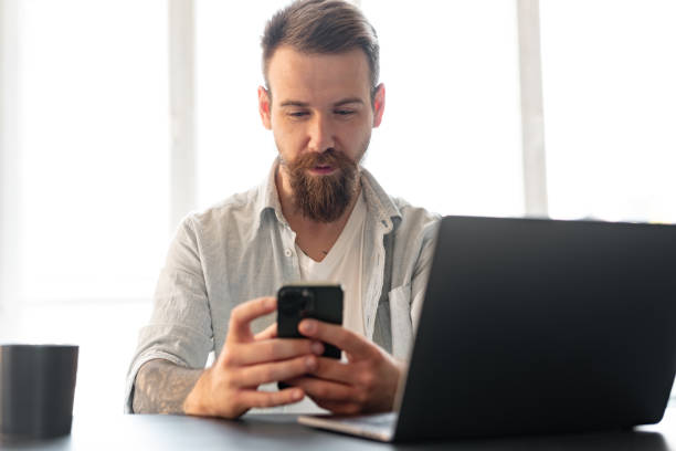 istock Handsome young bearded man spending time at home with phone in hands. 1428247785