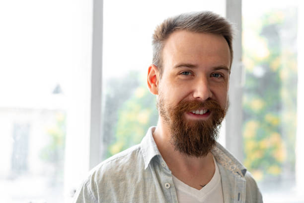 istock Bearded smiling handsome young man standing alone at home 1428247806