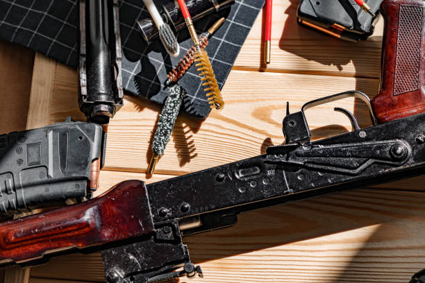 istock Black disassembled shotgun and cleaning tools on wooden table . 1428248029
