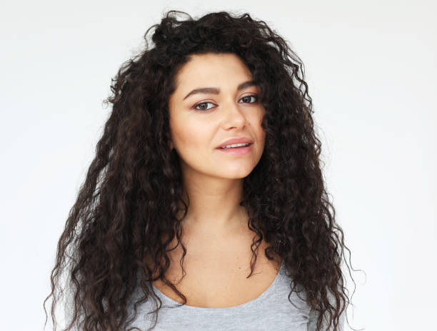young smiling mulatto woman with long curly haor wearing casual shirt, feel happy and smiling Young people, emotion and lifestyle concept: young smiling mulatto woman with long curly haor wearing casual shirt, feel happy and smiling, over white background beautiful mulatto women stock pictures, royalty-free photos & images