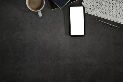 Smart phone with blank screen, keyboard, book and coffee cup on black background. Flat lay, Top view with copy space.