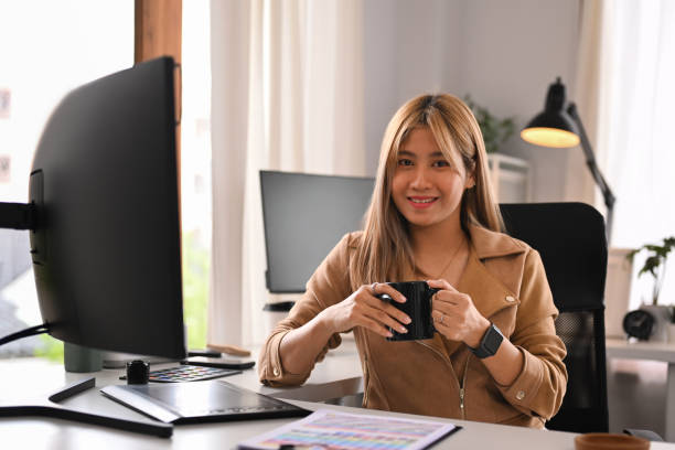istock Attractive young creative woman sitting front of professional computer in her home office and smiling to camera. 1428249775