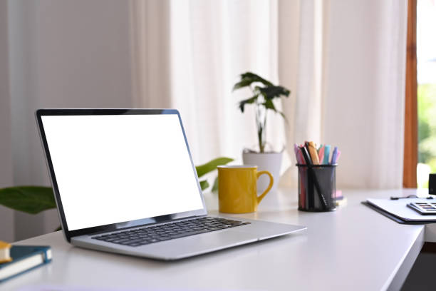 istock White office desk with laptop computer, coffee cup, potted plant and stationery. Comfortable workplace. 1428249806
