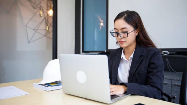 istock Asian businesswoman using laptop for work and doing internet research in her office. 1428253207