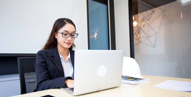 istock Asian businesswoman using laptop for work and doing internet research in her office. 1428253390