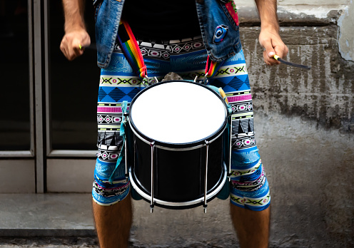 unrecognizable man drumming in the streets of barcelona in colorful costumes. Raising awareness of the LGBT community.