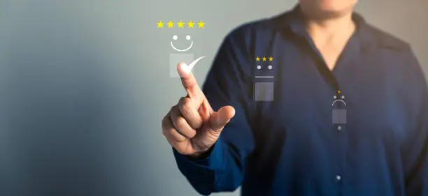 Photo of Customer service and Satisfaction concept, Business person are touching the virtual screen on happy Smiley face icon to give satisfaction in service. rating very impressed. customer service feedback.