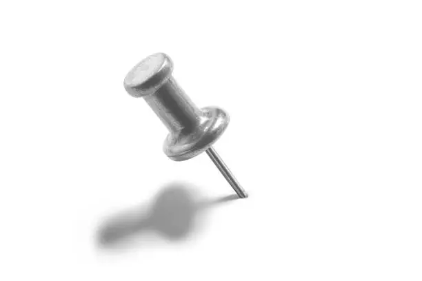 silver color push pin on a white background with shadows over them.