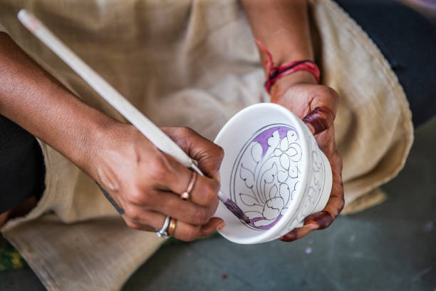 Woman painting Jaipur's Blue Pottery, Rajasthan, India Jaipur is famous for The Blue Pottery. The name 'Blue Pottery' comes from the eye-catching blue dye used to color the pottery. Blue colors designs are hand painted. india indian culture market clothing stock pictures, royalty-free photos & images