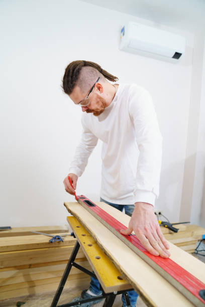 istock carpenter in protective glasses makes measurements and draws on wood 1428268538