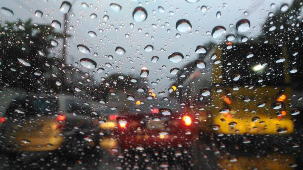 Drops of water on windshield and blur cars background.